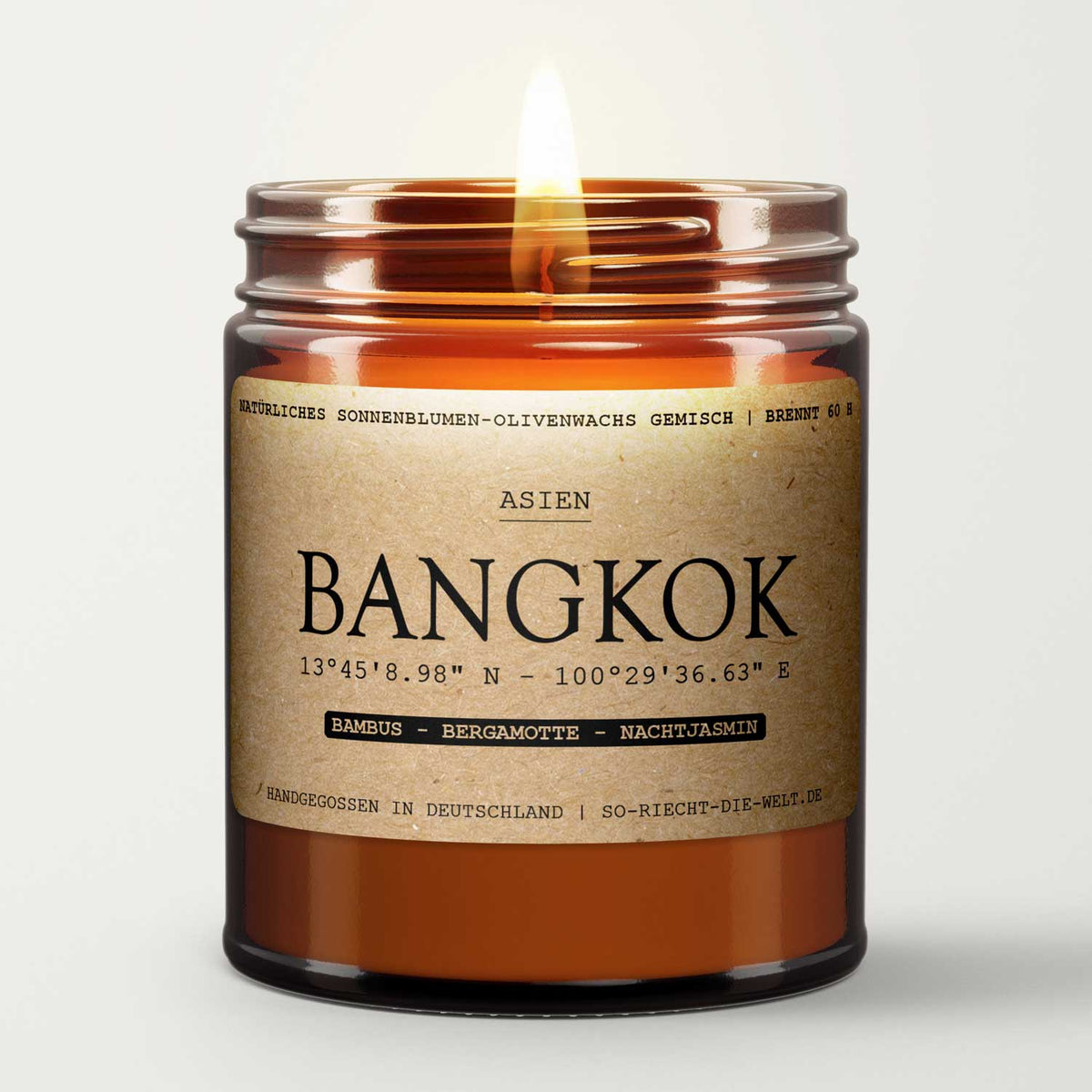 Brennende vegane Bangkok Duftkerze im braunen Apothekerglas mit Kraftpapier-Etikett.