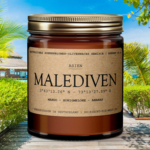 Malediven Duftkerze mit Mango- und Ananas-Duft vor einer tropischen Strand-Kulisse.