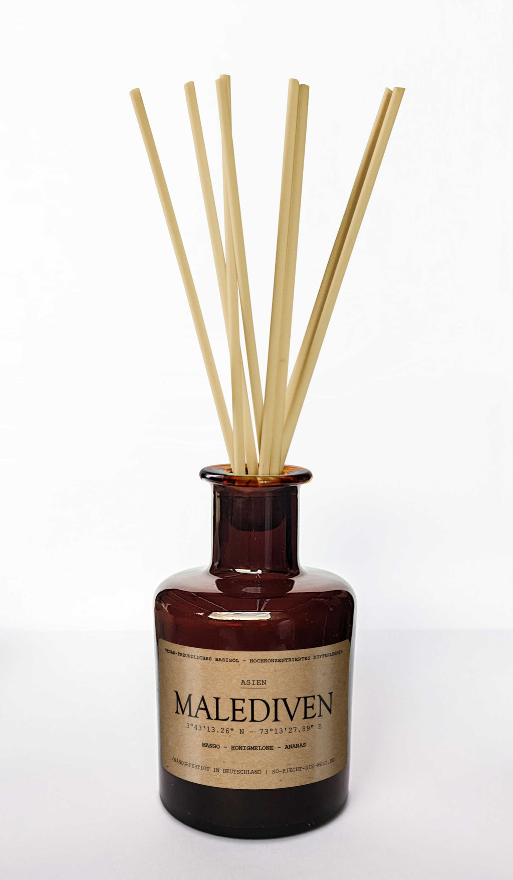 Malediven Aroma Diffuser im braunen Apothekerglas mit eingesteckten Duftstäbchen auf hellem Hintergrund.