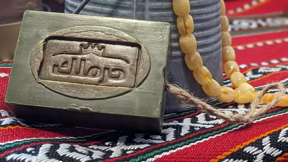 Detailansicht der traditionellen Aleppo-Seife mit klassischer arabischer Prägung auf gemustertem Untergrund.
