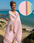 Frau in rosa Samimi Hamamtuch mit Rainbow-Streifen an der Küste mit Detailansicht der Webung.